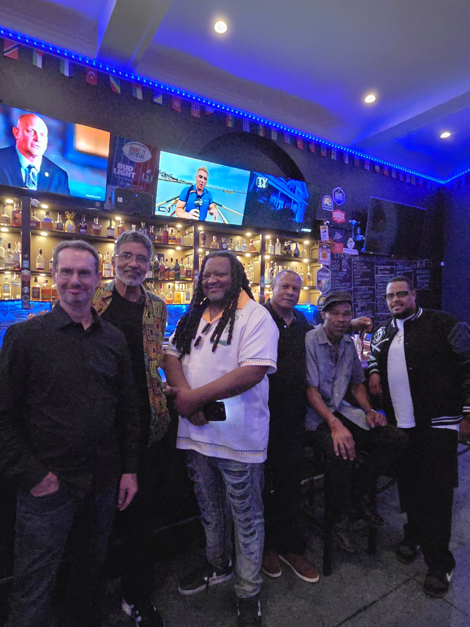 Alchemy Band members posing together at the bar before a live show